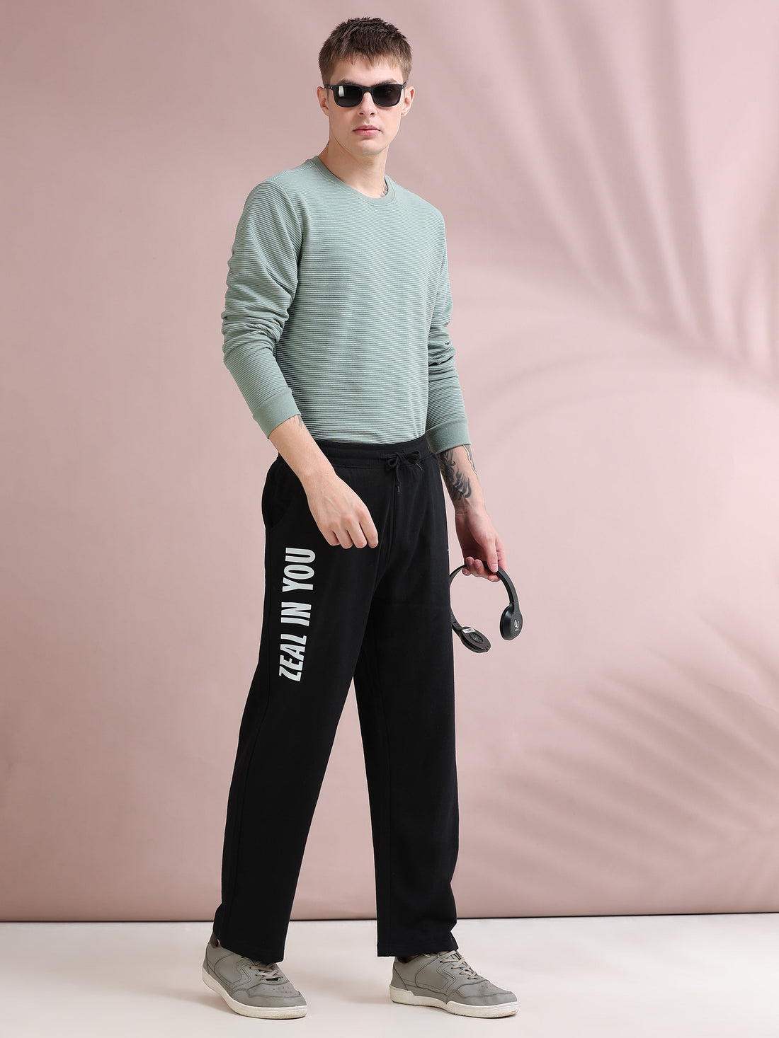 Man lounging on sofa in relaxed fit track pants and plain tee at home